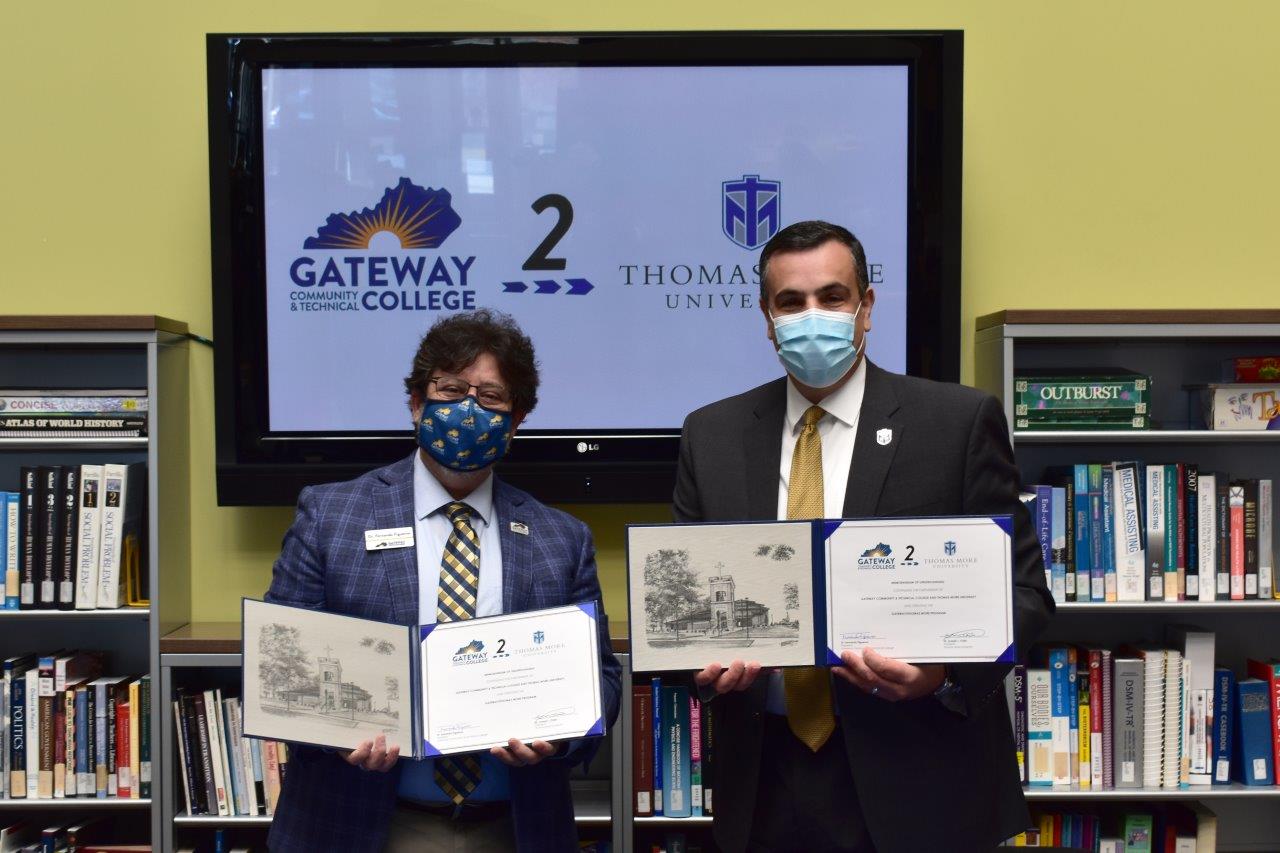 Dr. Figueroa and Dr. Chillo holding Gateway2Thomas More Agreements