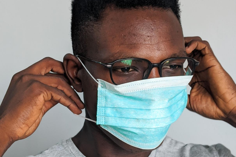 black male putting medical mask on