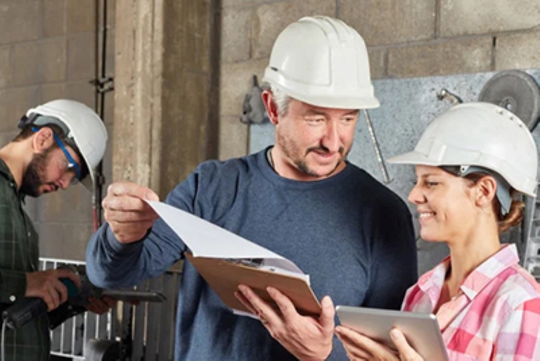 people with hard hats looking at documents