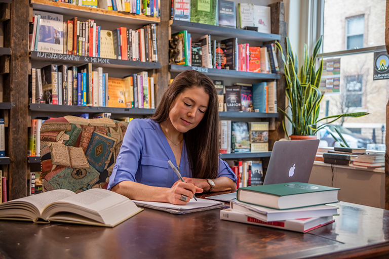 student in library working at a table