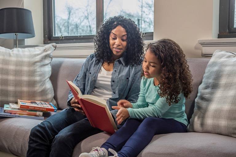 Mother reading daughter a book