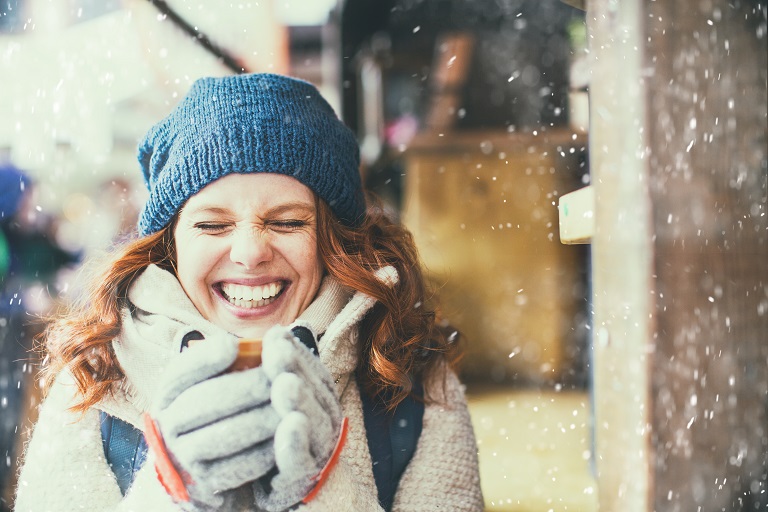 Woman holding coffee in the snow