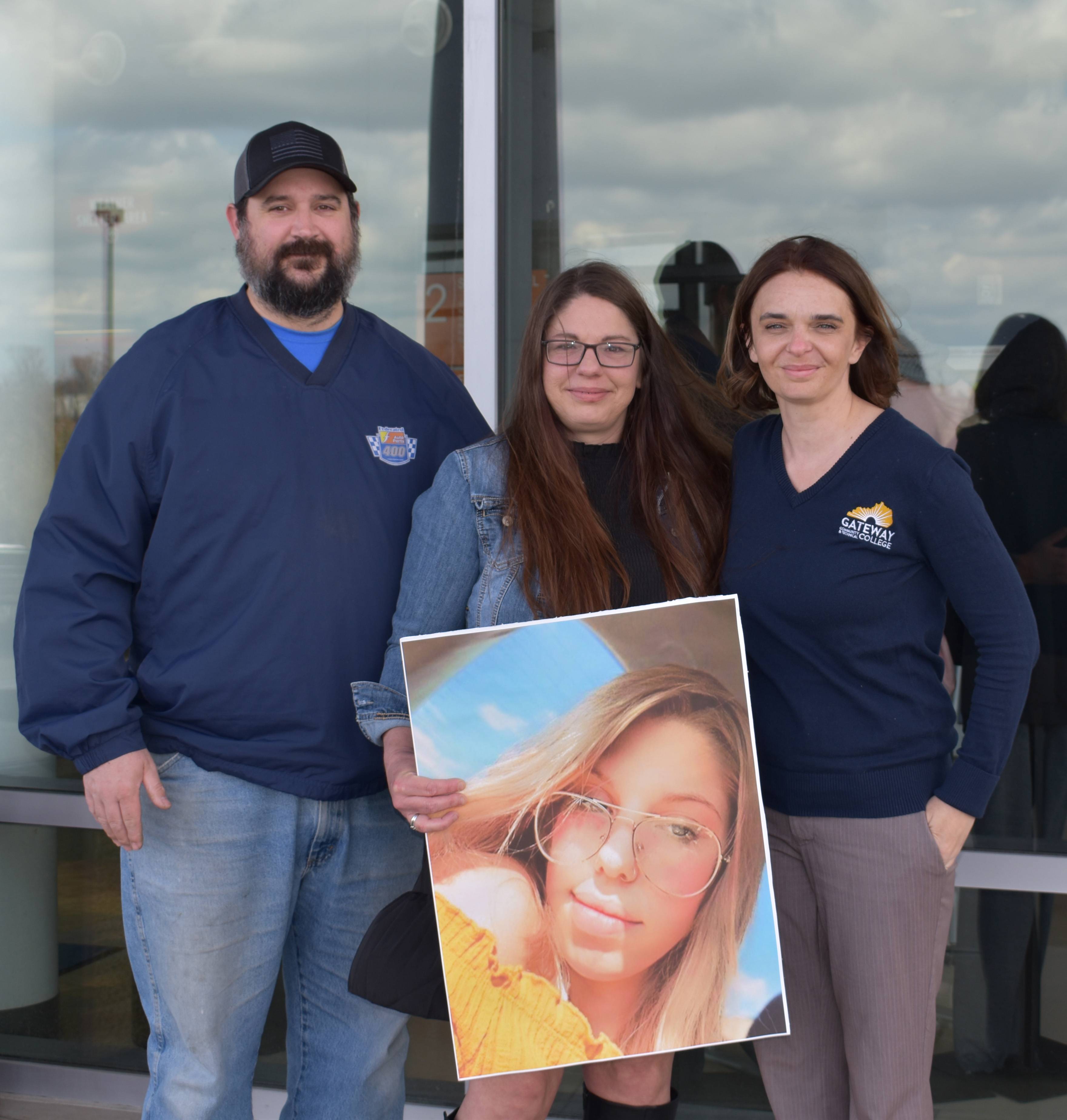 the Boothe Family with a picture of Raygan.